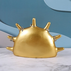 Detailed view of a golden palm-shaped resin ring display stand on marble surface