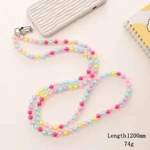 Colorful acrylic bead crossbody phone strap with metallic clasp on white wavy case