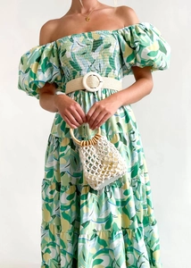Detail of off-shoulder floral dress with puff sleeves and a woven belt with circular buckle