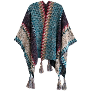 Macro view of ethnic style knitted poncho with colorful zigzag pattern and decorative hem tassels