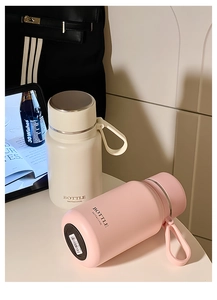 Detail of cream and pink matte stainless steel insulated bottles with carry handles