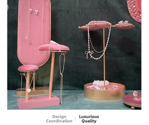 Pink velvet and gold metal jewelry display stands for necklaces and earrings in luxury style