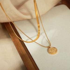 Double-layered gold chain anklet featuring snake chain and queen portrait coin pendant