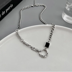 Dettaglio della collana in acciaio al titanio con ciondolo nero e anello lavico