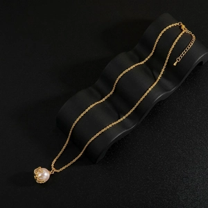 Close-up of elegant pearl pendant on golden crown setting with twisted chain detail