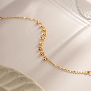 Macro shot of gold beaded bracelet with shimmering diamond-encrusted circular elements