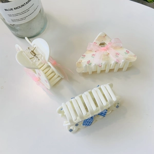 Detailed set of floral acrylic hair claws with bow accents in pink and blue patterns