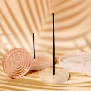 Macro detail of round resin incense holders with rippled texture and golden glitter