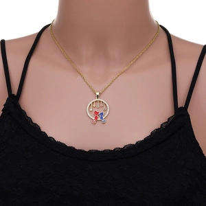 Close-up of golden necklace with hollow round cat pendant and colorful enamel details