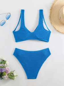 Flat lay of royal blue textured bikini set with removable pads and summer accessories