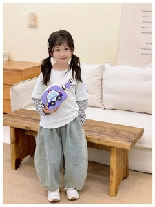 Detail of purple cartoon car chest bag with adjustable strap worn by a child model