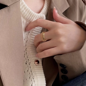 Close-up of golden double-layer chain drop ring on a hand for a minimalist layered look