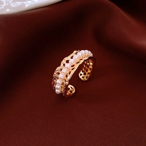 Macro shot of 18K gold plated hollow lace ring with elegant white pearl inlay