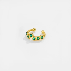 Close-up of gold ear cuff with green gemstones and vintage twisted texture on white background