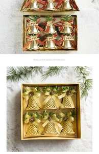 Close-up of golden Christmas bells set with red ribbons and pine cones on snowy background
