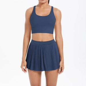 Front view of navy blue two-piece athletic yoga set with sports bra and pleated tennis skirt