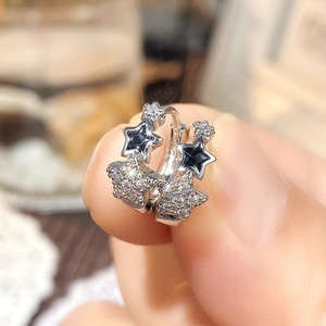 Macro view of sterling silver star earrings with pave cubic zirconia and black enamel