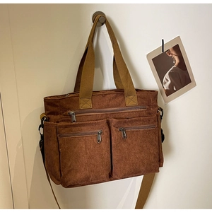 Detailed view of brown corduroy tote bag with multiple pockets and sturdy handles