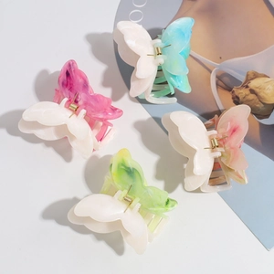 Detail of gradient butterfly hair claws with marble texture and strong metal springs