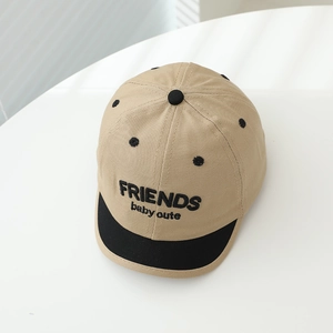 Close-up of baby baseball cap with Friends embroidery and contrast brim in soft light