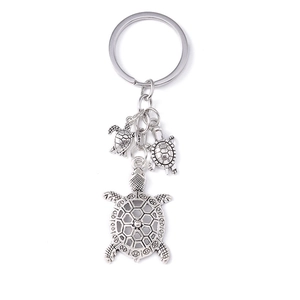 Silver vintage turtle keychain with three sea turtle charms on a white background