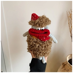 Close-up of handmade crochet monster doll bag with red hat and exaggerated lips
