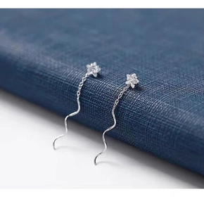 Macro di orecchini a stella in argento con linea ondulata e zirconi brillanti incastonati