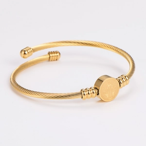 Gold stainless steel open bangle with spiral texture and Saint Benedict medal charm