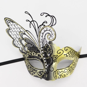 Detailed close-up of a butterfly masquerade mask with gold glitter and white rhinestones