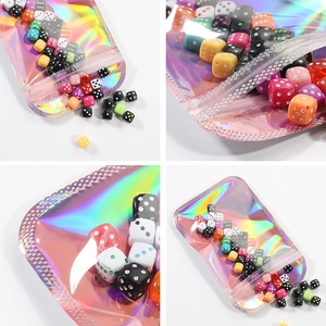 Colorful six-sided dice set in holographic laser resealable packaging on white background