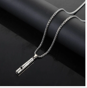 Detailed view of a silver whistle pendant necklace with a polished metal surface