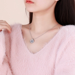 Pisces zodiac pendant necklace in silver stainless steel worn on a pink sweater