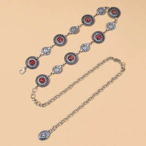 Detail of silver bohemian waist chain featuring vintage floral motifs and red stones