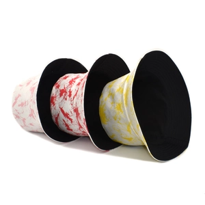 Detail view of colorful tie-dye bucket hats in pink, red and yellow cotton canvas