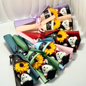 Close-up of graduation bear sunflower bouquets in colorful wrapping with gift tags
