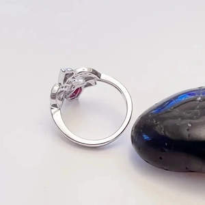 Macro view of silver hollowed heart ring with ruby gemstone and diamond setting