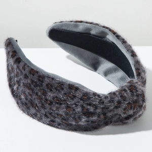 Détail du serre-tête en peluche léopard avec texture en fausse fourrure et doublure antiglisse