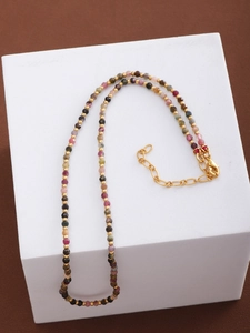 Detail of colorful faceted gemstone beads and gold metal spacers on adjustable necklace