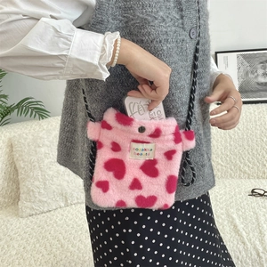 Détail du sac bandoulière en peluche rose à motifs cœurs rouges et fermoir bouton pression