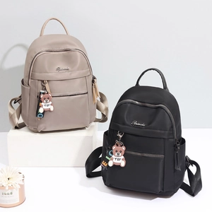 Minimalist Oxford fabric backpack in black and khaki with a cute bear charm accessory