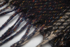 Detailed view of multicolored knit texture and fringe tassels on winter scarf