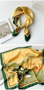 Detailed pattern of a silk scarf with golden lotus flowers and elegant crane print