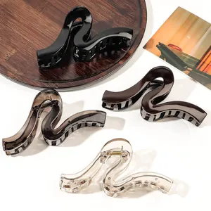 Detailed view of large wavy hair claws in four colors on a modern decorative tray