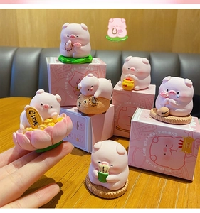 Close-up of cute pink pig resin figurines with artistic packaging for desk decor