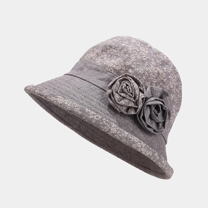 Detail of grey cotton bucket hat for elderly women with decorative fabric floral accents
