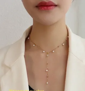 Detail of elegant Y-shaped pearl tassel necklace with 18k gold plating on the model's neck