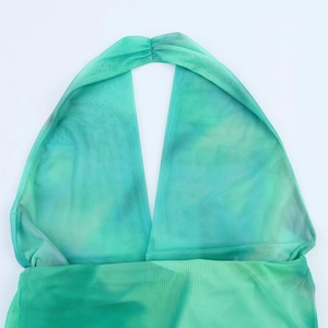 Detailed close-up of the deep V-neckline and mesh texture on emerald green tie-dye top