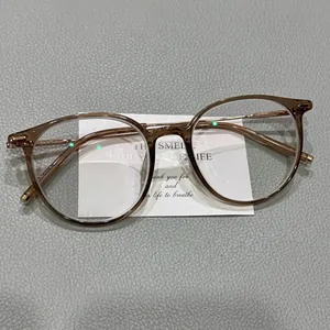 Close-up of retro amber translucent round glasses frame with gold metal accents