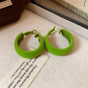 Close-up of green velvet-flocked C-shape hoop earrings with vintage matte texture