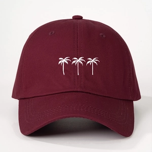 Detailed embroidery of three white coconut trees on a burgundy cotton baseball cap